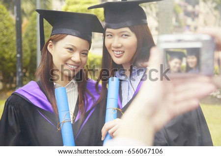 University students in graduation robe posing for the camera
