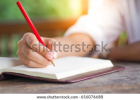 Women write books with red pencil.