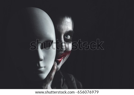 clown hiding his self behind anonymous white mask Royalty-Free Stock Photo #656076979