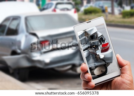 Close up hand holding smartphone and take photo of car accident