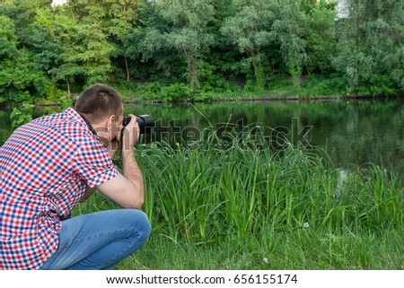 Photographer is shooting on the background of the river