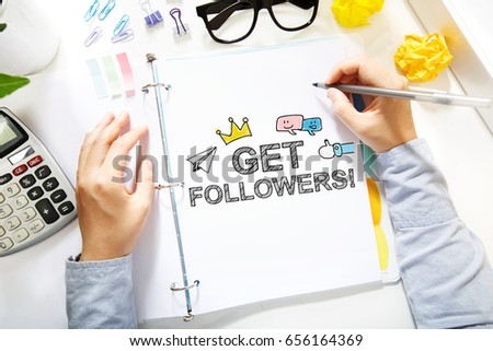 Person drawing Get More Followers concept on white paper in the office