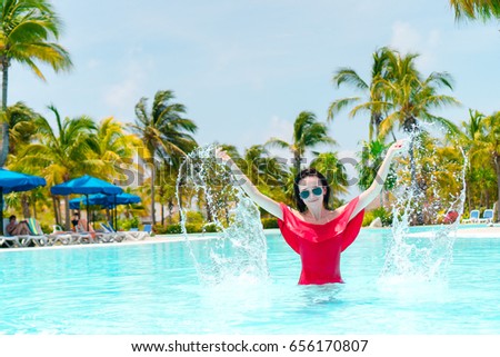 Beautiful young girl relaxing in the swimming pool outdoors