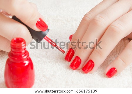 Manicure - Beautiful manicured woman's nails with red nail polish on soft white towel. Royalty-Free Stock Photo #656175139