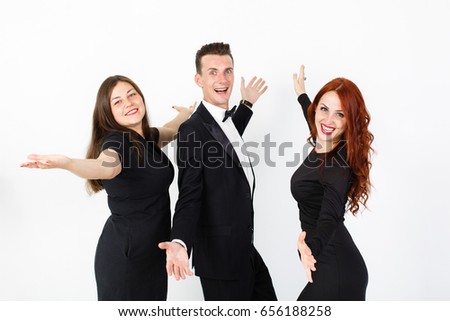 Young man and two women in black on a white background. Trio band of  actors performing on the stage. Smiling team of man and two women on white background with copy space