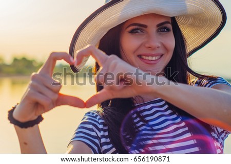 Cheerful girl shows heart