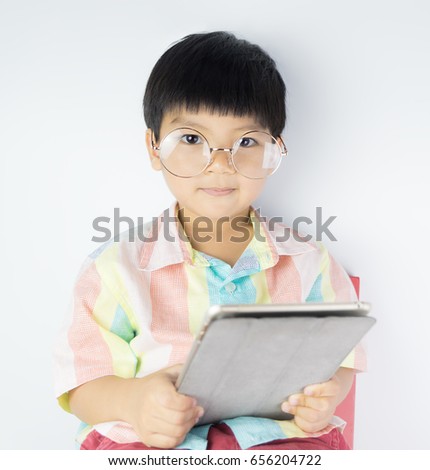 Nerdy Asian boy is holding a tablet isolated on white