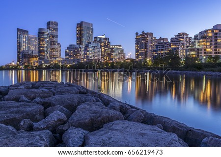 Buildings lit up at nighttime at Toronto's lakeshore. 