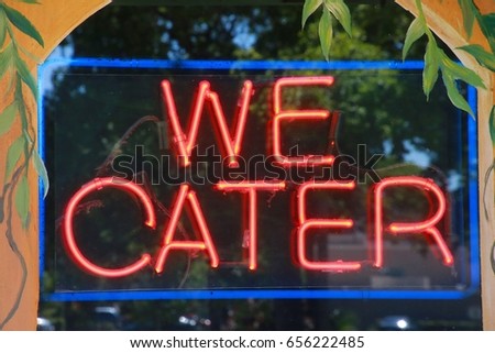 We Cater Red and Blue Neon Sign in Restaurant Window