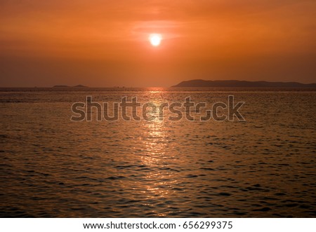 Scenic view of beautiful sunset above the sea. Mountain on background

