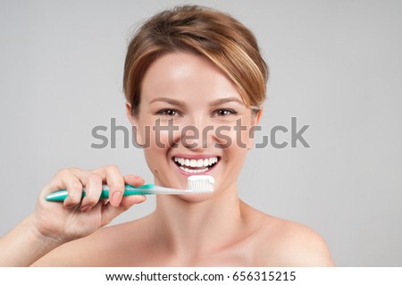 Happy young woman brushing teeth. Beautiful smile and white teeth