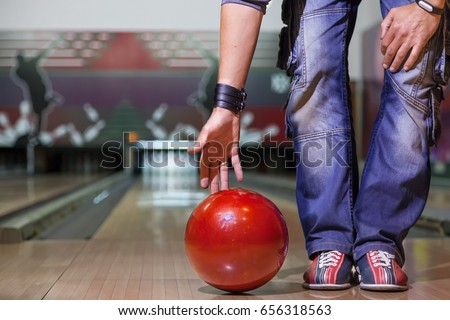 the hand throws the bowling ball, a man's hand throws a bowling ball close-up, a man plays bowling on the background of the playing field