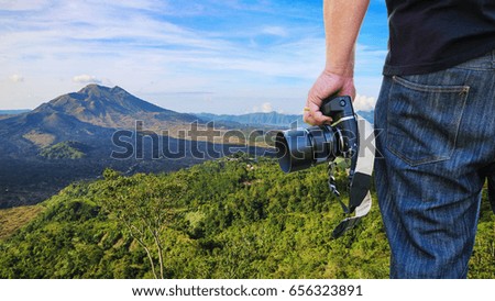 Close-up shot of man holding camera standing on the hill
