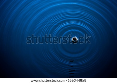 Top view Closeup water drop on blue water rings, Circle reflections in pool. Royalty-Free Stock Photo #656344858