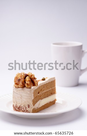Walnut cake on the white plate with a cup of coffee