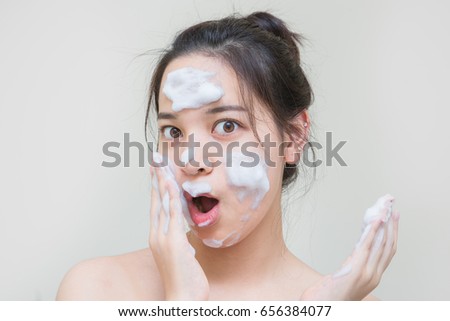 beautiful Asian young girl enjoy skin care product that she apply on her facial skin Royalty-Free Stock Photo #656384077
