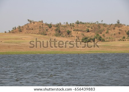 landscape view of lake and small  hill from boat at dudhni india