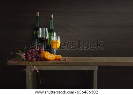 Pile of Fruits and bottle wine with glass put on the plank in dim light / Still Life image and selective focus with Space for text, adjustment for header, banner, cover

