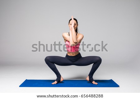 Young attractive woman practicing yoga, standing in different yoga exercise, wearing sportswear isolated on grey background. Yoga position concept