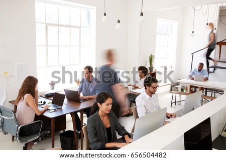 Young business colleagues working in a busy open plan office Royalty-Free Stock Photo #656504482