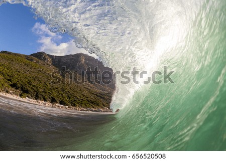 wave breaking on beach beneath mountains