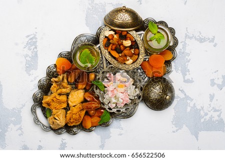 Ramadan Kareem holiday table with dry fruits, nuts, dates, baklava. Eastern abundance. Copy space
