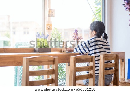 Young girl sitting at a cafe. Sitting on wood chair.