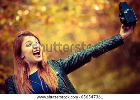 Beauty makeup nature forest autumn concept. Ginger girl taking selfie. Young attractive redhead lady takes picture of herself.