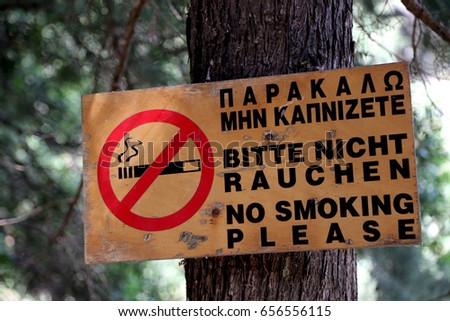Sign saying "No smoking please" in Greek, German and English language in a forest in Imbros gorge, Crete, Greece