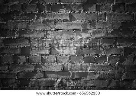 Black brick wall with spot illumination, frontal flat detailed background texture