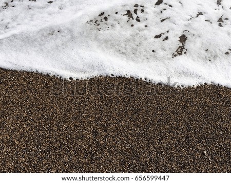 Background with small pebbles stone and foam from the sea