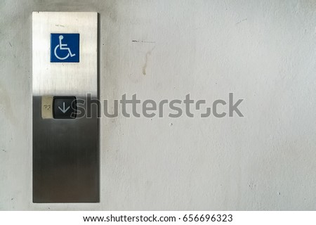 Disability signage elevator button with the down button on old wall, copy space for free text