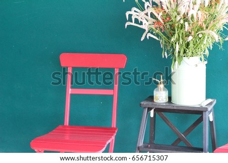 Red wooden chair with beautiful flower vase