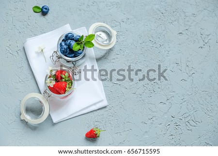 Fresh strawberries and blueberries in glass pots Top view Copy space