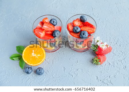 Diced fresh fruits and berries in glasses Summer time Top view 