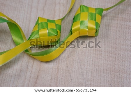 Ketupat decoration on wooden table, there is a blank space to write. Ketupat is traditional food in Malaysia during the Hari Raya celebration.