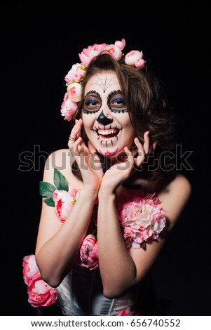 Halloween makeup beautiful brunette woman. Studio portrait of a dark picture. Santa Muerte concept.