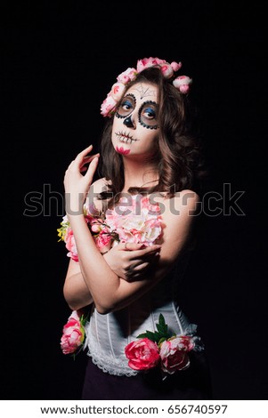 Halloween makeup beautiful brunette woman. Studio portrait of a dark picture. Santa Muerte concept.