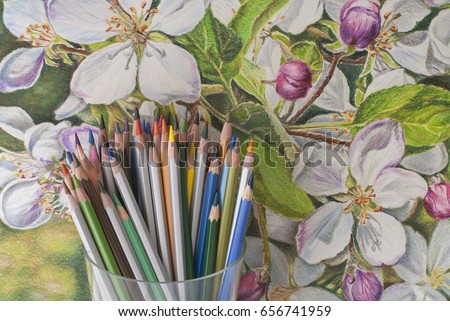 A bunch of colored pencils on the background of a drawing with colored pencils