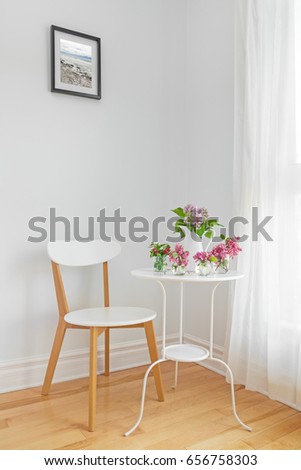 White interior with modern furniture and spring flowers. Elegant home decor.