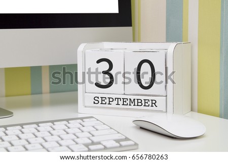 Cube shape calendar for SEPTEMBER 30 and computer keyboard on table. 