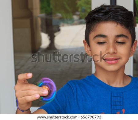 Young boy play with fidget spinner stress relieving toy