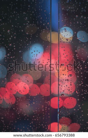 Bokeh lights background, Water drops on the windscreen front of the car, abstract bokeh lights in a rainy day with traffic jam in the night on the road. abstract blurred defocused background