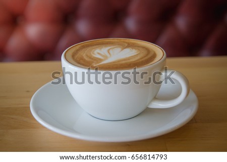A cup of coffee late art with space on  wood background,vintage picture style