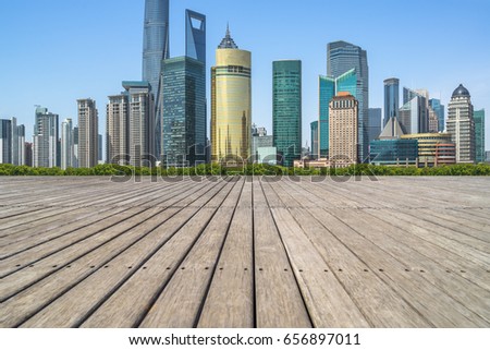 cityscape and skyline of shanghai in blue sky from empty wooden footpath