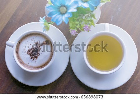 Cup of coffee and tea on the wood table, expressing concepts of love, care, cozy, and couple