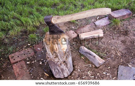 the axe side is inserted in the woodpile