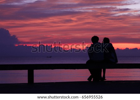 silhouette of lovers on the beach after sunrise