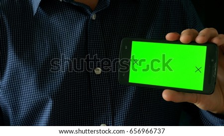 Smartphone with green screen in hand