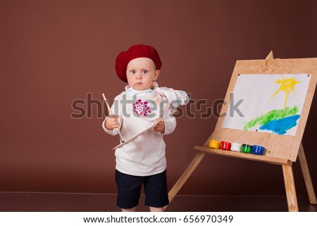 boy artist brush and paints paints a picture